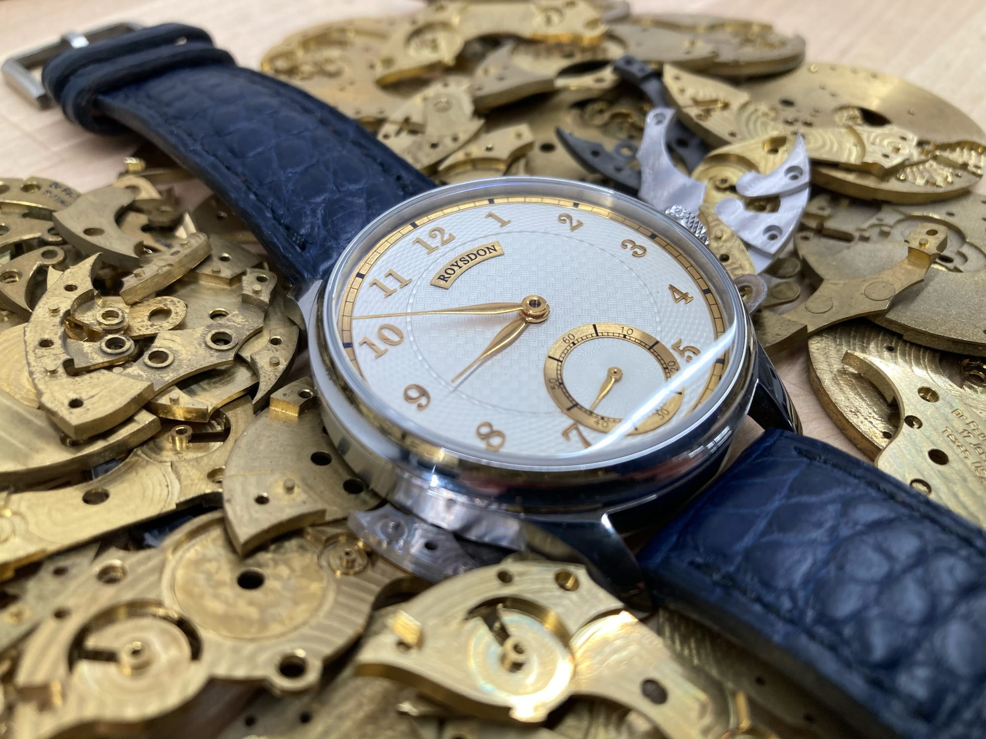 Finished Roysdon watch resting on machined movement plates and bridges