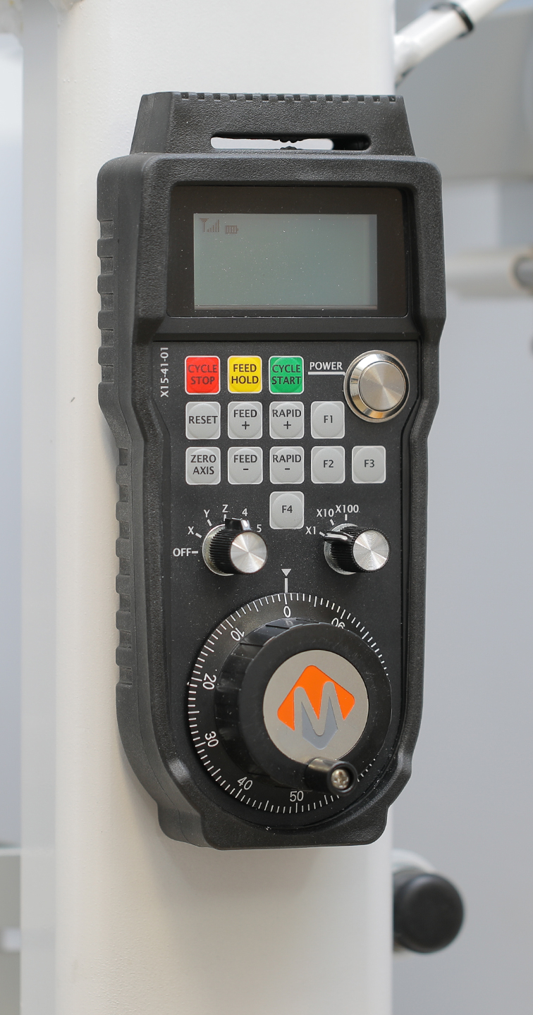 Larger MPG pendant with an LCD display and dedicated keys for cycle start, feed hold, cycle stop, feed and rapid override, and axis zeroing, above the axis and step selectors and the jog handwheel
