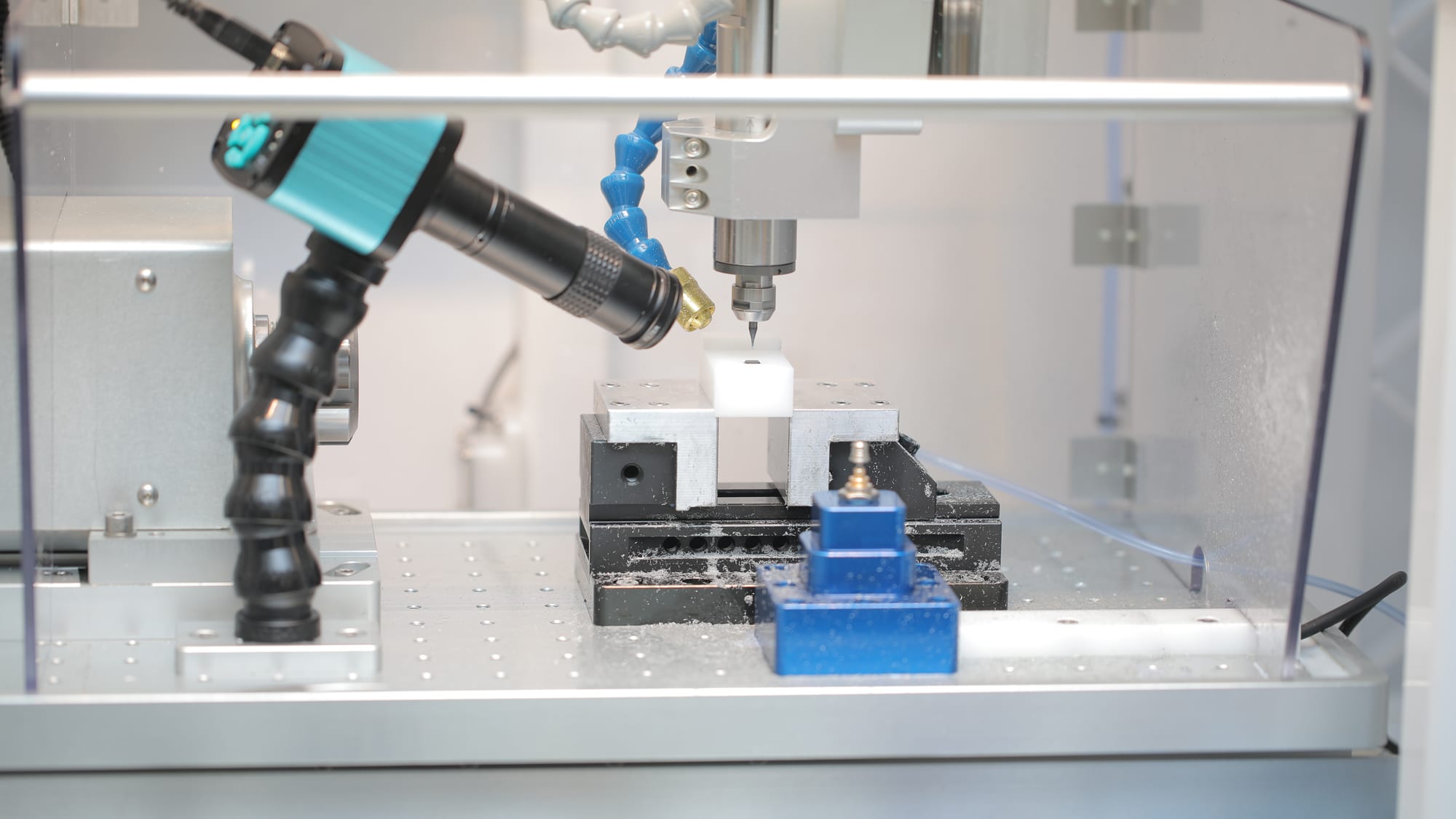 Microchip analysis setup inside the machine enclosure, with an inspection camera aimed at the fixtured chip