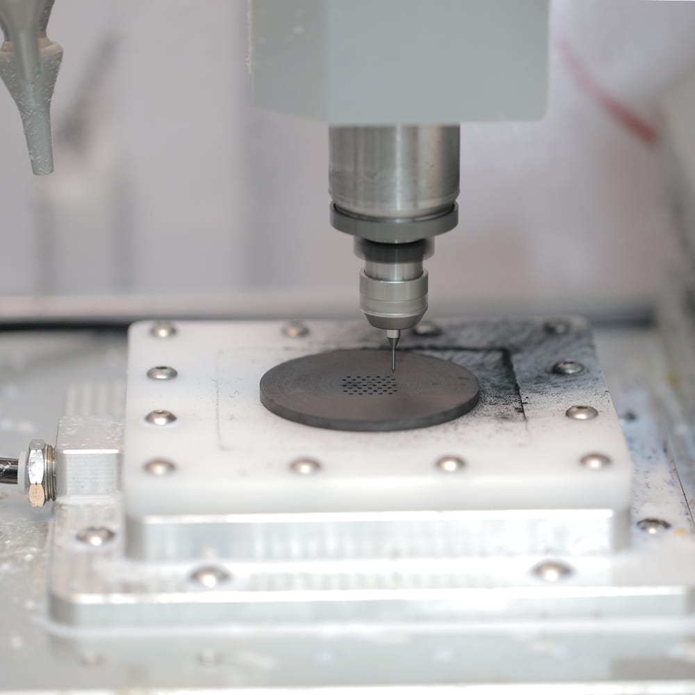 Elara 2 drilling a graphite disc held in a custom vacuum holder