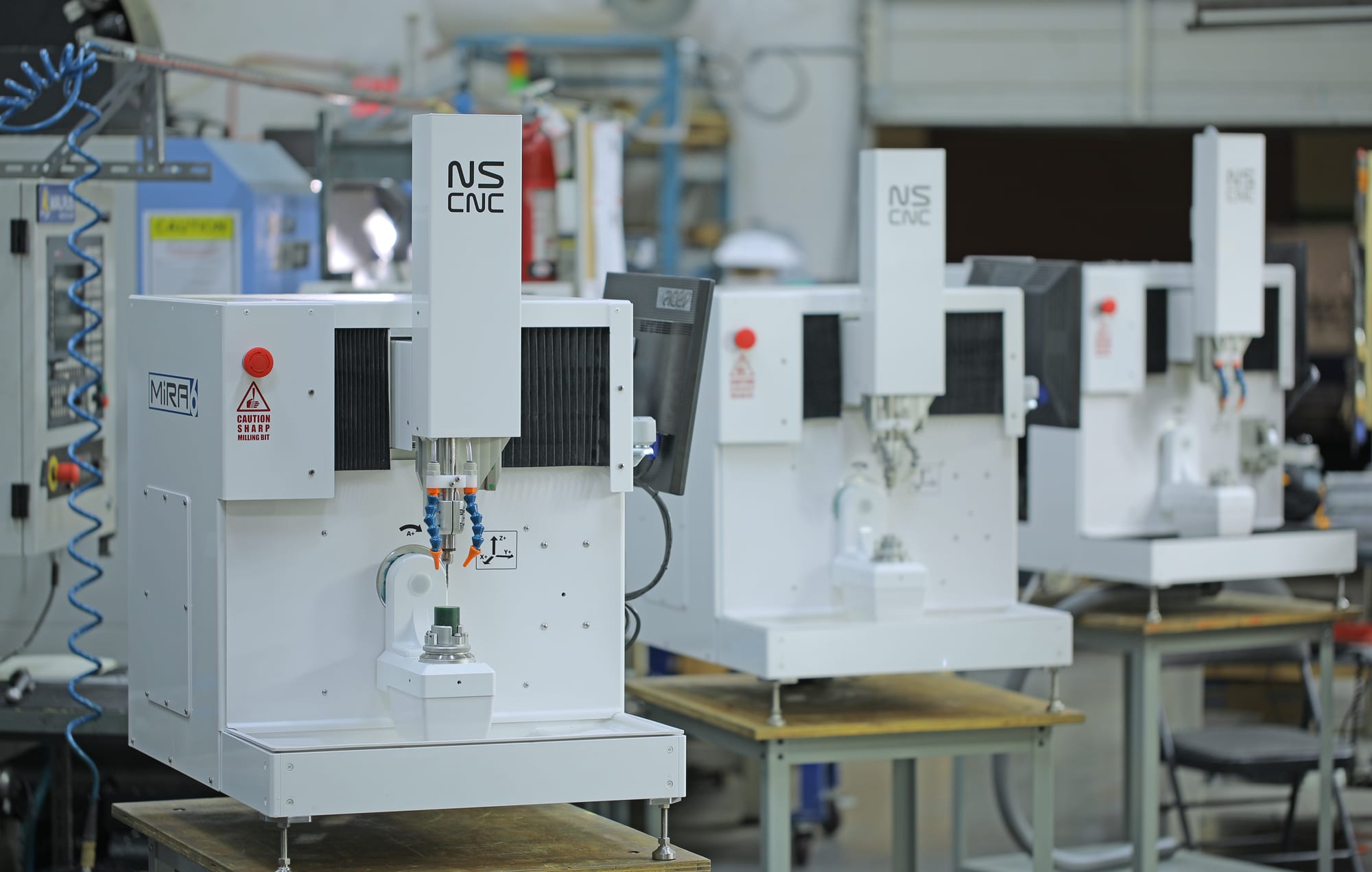 A row of NS CNC mills on the shop floor