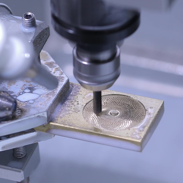 A fine radial pattern being engraved into a brass plate